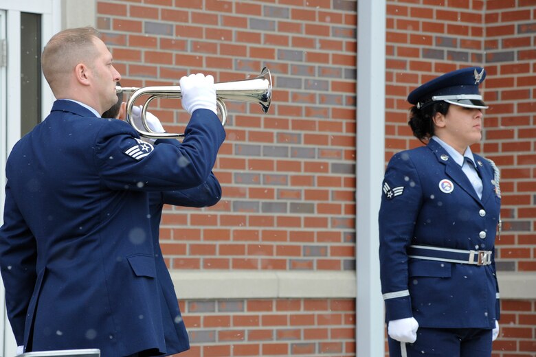 Staff Sgt. Daniel Rineer plays “Taps” on a bugle during a training session of the 127th Wing Honor Guard at Selfridge Air National Guard Base, Mich., Feb. 10, 2012. Standing at attention is Senior Airman Elizabeth Licari who was serving as the honor guard commander during the training. (U.S. Air Force photo by John S. Swanson)