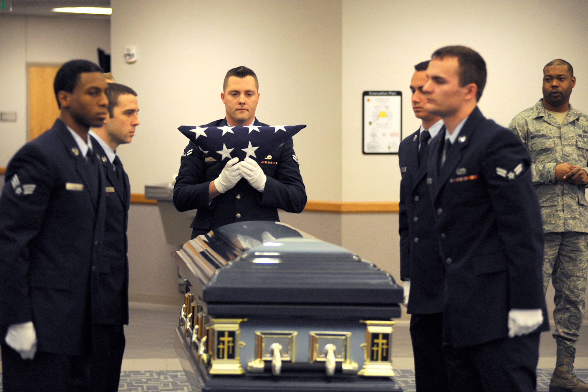 Airman 1st Class Shane Shaltry holds the U.S. Flag after it is folded over a casket by members of the 127th Wing Honor Guard at Selfridge Air National Guard Base, Mich., Feb. 10, 2012. In addition to the empty casket, volunteers acted as “grieving family members” to assist honor guard trainees learn the appropriate ceremonial honors to be rendered at a veteran’s funeral. The honor guard held a training session to qualify six new Airmen to serve as members of the unit. (U.S. Air Force photo by John S. Swanson)