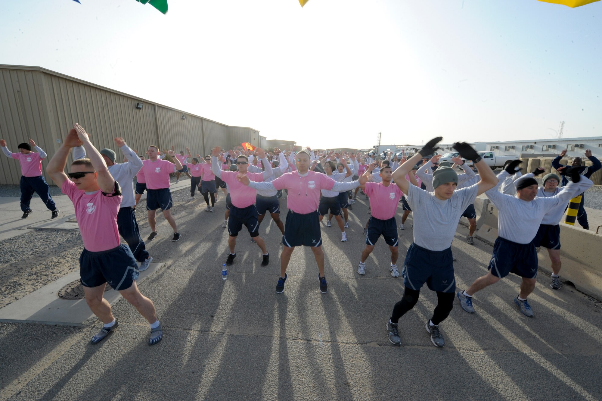 332nd Air Expeditionary Wing members do jumping jacks to warm up for the "Cupid's Love Run" at an undisclosed location in Southwest Asia, Feb. 14, 2012. The run kicked off a series of events put on by the 332nd Expeditionary Force Support Squadron for Valentine's Day. (U.S. Air Force photo by Staff Sgt. Joshua J. Garcia/Released)