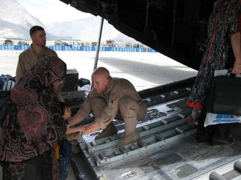 U.S. Air Force Tech. Sgt. Matthew Stiles lifts a Pakistani boy onboard their aircraft during the 2010 floods. (Courtesy photo)