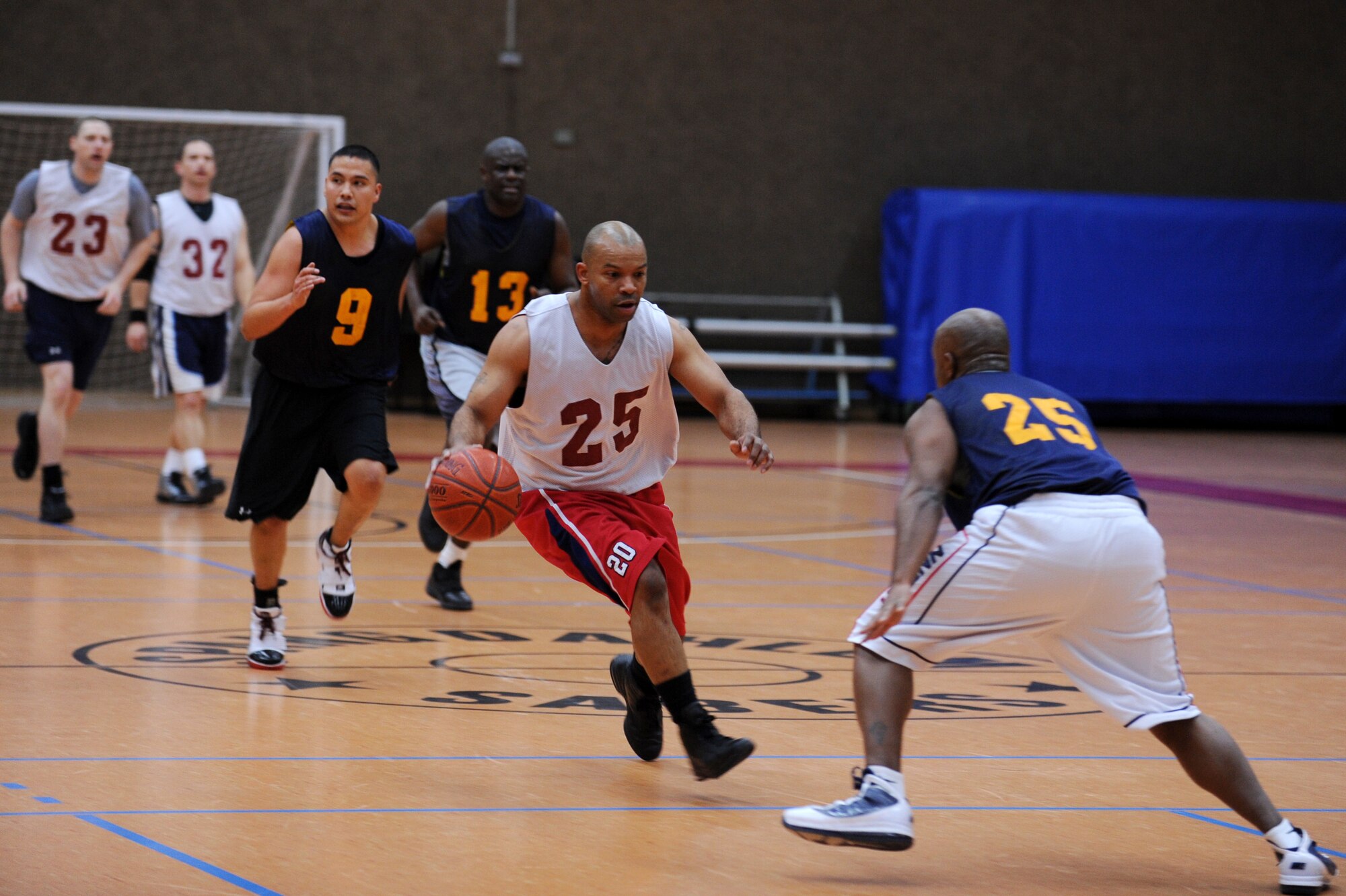 SPANGDAHLEM AIR BASE, Germany – Mark Childs, 726th Air Mobility Squadron, drives past Richard Goines, 52nd Communications Squadron, during the over-30 basketball league championship game at the Skelton Memorial Fitness Center here Feb. 13. The AMS defeated the CS 48-35 to win the championship game with an undefeated record. (U.S. Air Force photo by Airman 1st Class Matthew B. Fredericks/Released)