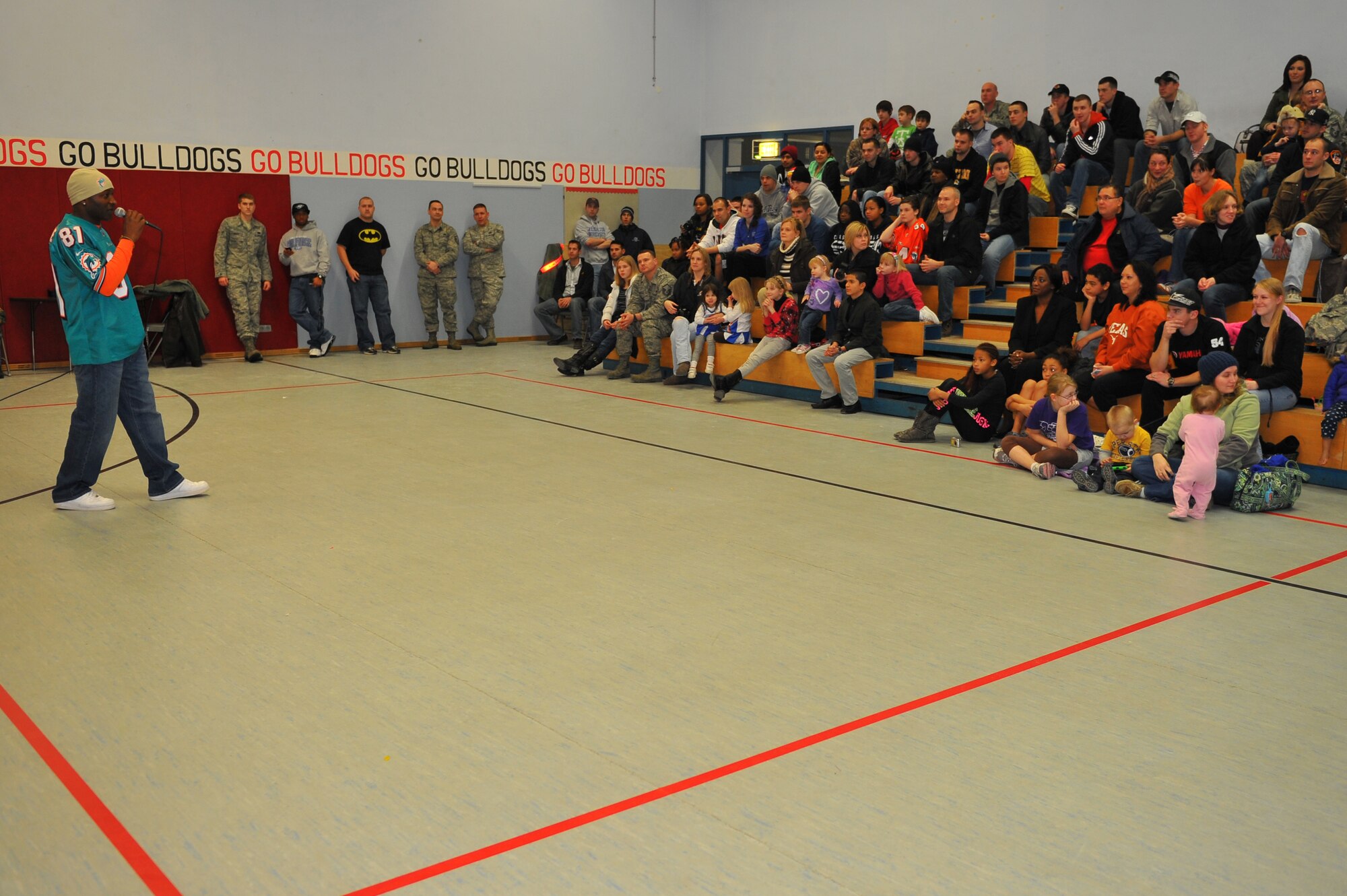 SPANGDAHLEM AIR BASE, Germany – O.J. McDuffie, retired Miami Dolphins wide receiver, answers questions asked by people attending a cheerleader demonstration at the Spangdahlem Middle School here Feb. 10. The Miami Dolphins football players and cheerleaders toured various U.S. Air Force and Army bases in Europe as part of an Armed Forces Entertainment tour. The reason for the visit was to boost morale and entertain the base’s community. (U.S. Air Force photo by Airman 1st Dillon Davis/Released)