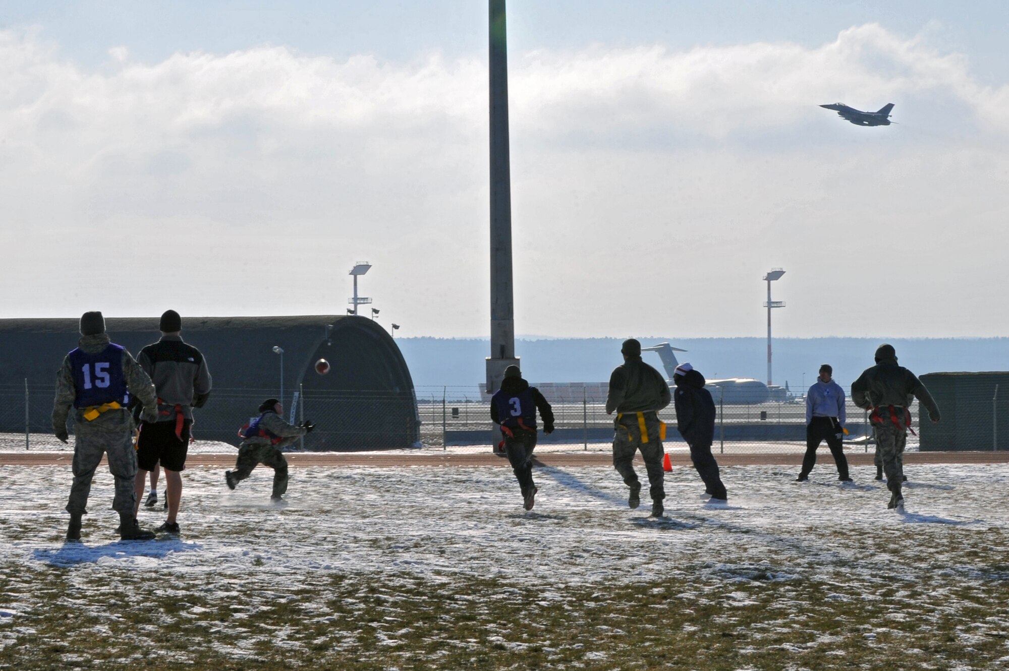 SPANGDAHLEM AIR BASE, Germany – Airmen and family members participate in a flag football game outside the Skelton Memorial Fitness Center here Feb. 10. The Armed Forces Entertainment sponsored the tour and retired Miami Dolphins football players coached the flag football teams during their visit. The Miami Dolphins football players and cheerleaders toured various U.S. Air Force and Army bases in Europe. The reason for the visit was to boost morale and entertain the base’s community. (U.S. Air Force photo by Airman 1st Dillon Davis/Released)