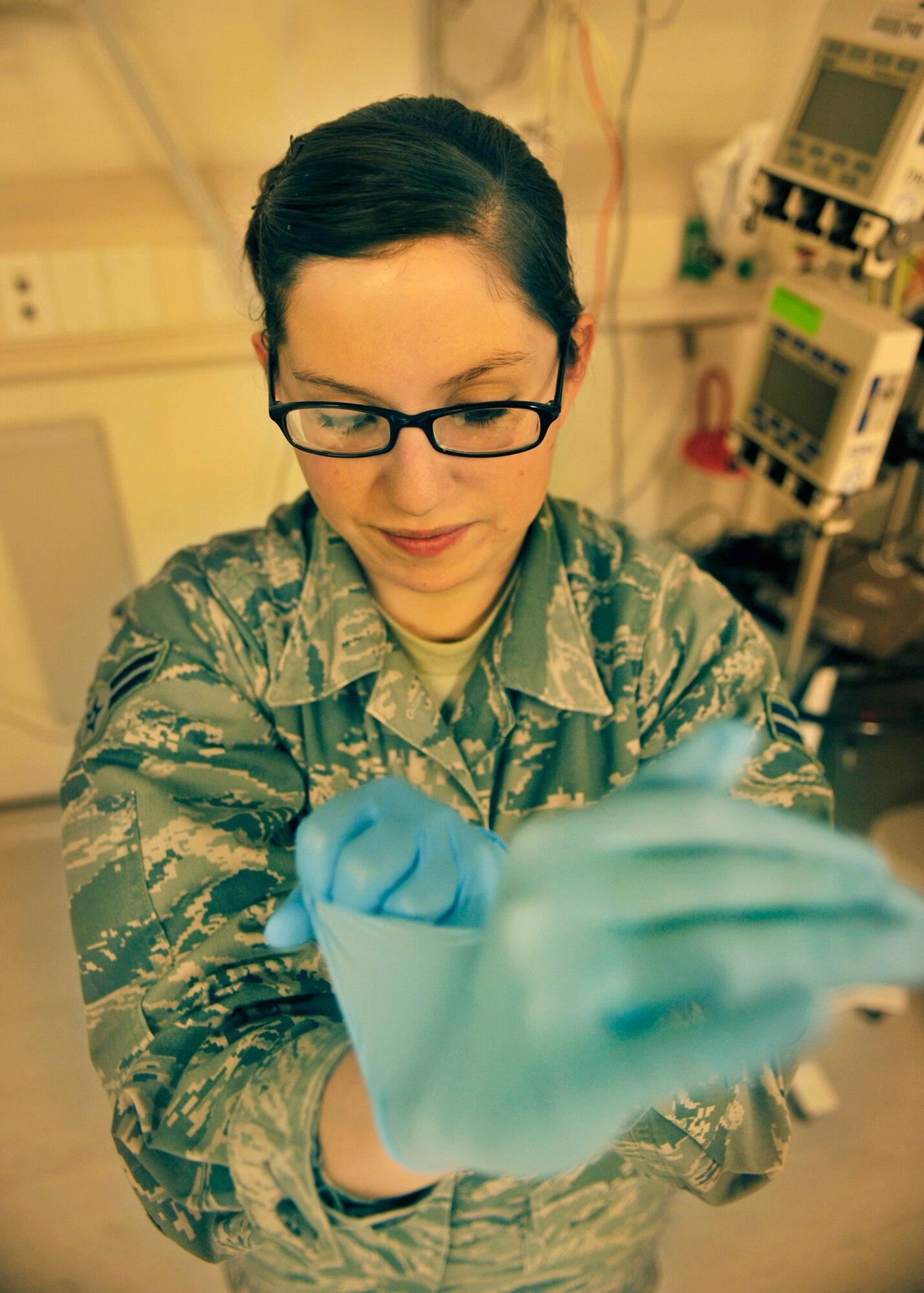 BAGRAM AIRFIELD, Afghanistan—Airman 1st Class Samantha Bird pulls on surgical gloves at Bagram Airfield, Afghanistan, Feb. 14, 2012. Bird is a medical technician with the 455th Expeditionary Medical Operations Squadron and earned the Warrior of the Week award for her hard work and dedication to excellence. (U.S. Air Force photo/ Airman 1st Class Ericka Engblom)