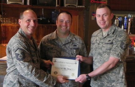 Master Sgt. Brady Durr (left) and Master Sgt. Christopher Wilson (center) present a Top-3 coin and certificate to Tech Sgt. Matthew Ancell for being selected as a Top-3 Monthly Outstanding Performer at Joint Base Charleston – Air Base Feb. 8. Each month, the Top-3 organization recognizes Airmen who have made a significant impact on their unit’s mission. Ancell and Wilson are assigned to the 437th Maintenance Group, 437th Airlift Wing. Durr is assigned to the 437th Operations Support Squadron, 437th AW and is the Top-3 president. (Courtesy photo)