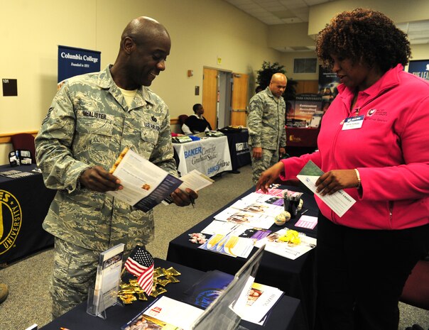 Tech. Sgt. Kevin McAlister picks up program information from one of the booths at the Education Fair held at Joint Base Charleston – Air Base Feb. 10.  The fair was open to all military, family members and retirees. Thirty four colleges and universities participated. McAlister is the 315th Airlift Wing Force Support Squadron support staff non-commissioned officer in charge.  (U.S. Air Force photo/ Staff Sgt. Nicole Mickle)   