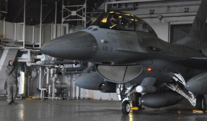 U.S. Air Force Airman 1st Class Luis Torres-Belardo, 13th Aircraft Maintenance Unit crew chief, talks to a pilot before taxing an F-16 Fighting Falcon to the runway for a flight to exercise Cope North at Misawa Air Base, Japan, Feb. 10, 2012. More than 10 aircraft left Misawa to participate in the exercise at Anderson Air Force Base, Guam. (U.S. Air Force Photo by Tech. Sgt. Phillip Butterfield/Released)