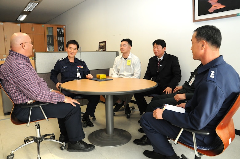 Tim Masters (left), U.S. Army Corps of Engineers, Far East District Quality Assurance Representative, talks with Col. Han Bong-wan (second from left), Chief of U.S. Forces Korea Construction Management Team, Ministry of National Defense-Defense Installation Agency.  Han presented Masters with an award from Maj. Gen. Park Kye-su, director of MND-DIA, Dec. 6 for his most recent work on the new dining facility at Camp Carroll.