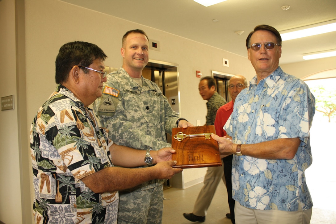 Honolulu District engineer and project manager Owen Ogata (left) and Honolulu District Commander Lt. Col. Douglas Guttormsen present a ceremonial key to the newly constructed Unaccompanied Enlisted Personnel Housing at Schofield Barracks to Directorate of Public Works Director Bob Eastwood.