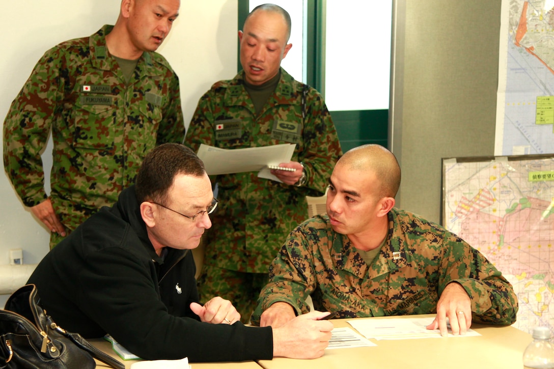 Captain Nikolas H. Aiona-Aka, Japanese linguist, Marine Air Logistics Squadron 16, 3rd Marine Air Wing, works James Whitlatch, Theater Support Coordination planner, during a staff planning exercise at Edson Range, Jan. 24. The JGSDF are here to participate in Exercise Iron Fist 2012 with the 15th Marine Expeditionary Unit, a unique training opportunity for both services.