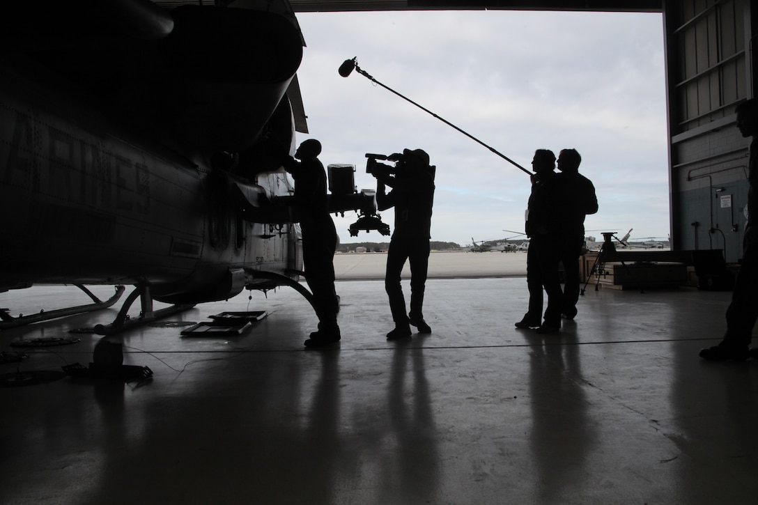Lance Cpl. Jeff Kruger shows a camera crew the engine of an AH-1W Super Cobra at the Marine Light Attack Helicopter Squadron 467 hangar aboard Marine Corps Air Station Cherry Point Feb. 14. The crew conducted interviews and recorded footage of the aircraft as it demonstrated capabilities for the History Channel’s TV show, “101 weapons that changed the world.” Kruger is a Super Cobra and Huey mechanic with HMLA-467.