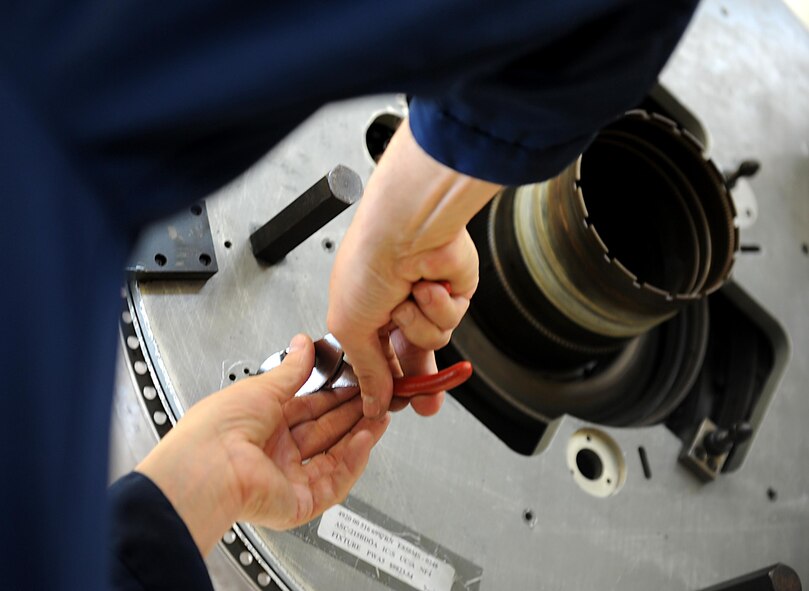 U.S. Air Force Brig. Gen. Matthew Molloy, 18th Wing commander, tightens a bolt while working on a Prat and Whitney F100-220 afterburning engine on Kadena Air Base, Feb. 15, 2012. The engine is used to power the U.S. Air Force F-15 Eagle fighter jet. (U.S. Air Force photo by Airman 1st Class Brooke P. Beers) 