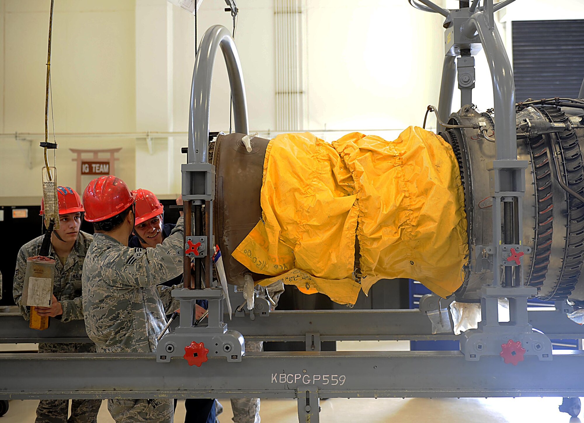 Airmen from the 18th Component Maintenance Squadron work with U.S. Air Force Brig. Gen. Matthew Molloy, 18th Wing commander, to remove a high pressure turban from a jet engine, on Kadena Air Base, Feb. 15, 2012. Molloy visited the squadron to learn about and participate in what the 18th CMS Airmen do daily. (U.S. Air Force photo by Airman 1st Class Brooke P. Beers) 