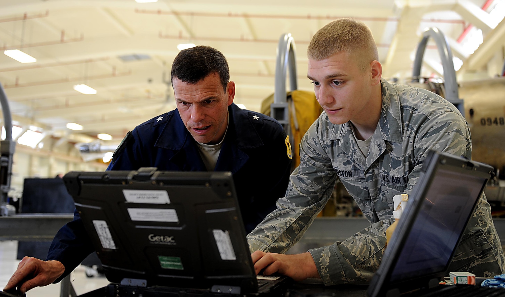 U.S. Air Force Senior Airman Andrew Huston, 18th Component Maintenance Squadron aerospace propulsion technician, reviews technical orders with U.S. Air Force Brig. Gen. Matthew Molloy, 18th Wing commander, on Kadena Air Base, Feb. 15, 2012. General Molloy visited the squadron to learn about and participate in what the 18th CMS Airmen do daily. (U.S. Air Force photo by Airman 1st Class Brooke P. Beers) 