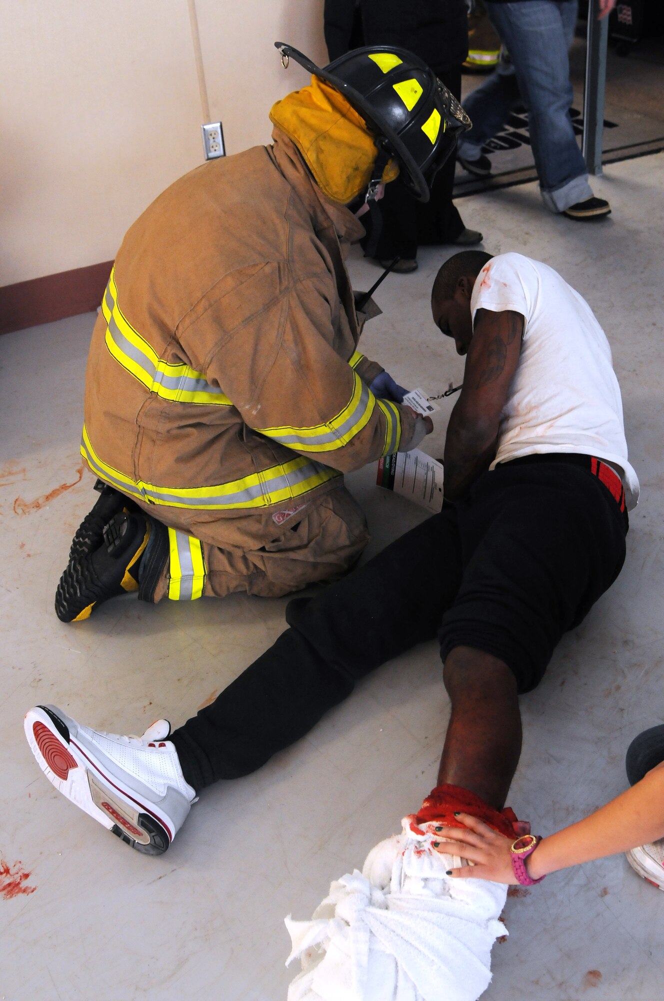 Airman 1st Class Darren Palmer, 354th Force Support Squadron fitness specialist writhes in simulated agony as a Fairbanks firefighter provides care during exercise Alaska Shield 2012, a state-wide exercise Feb. 8, 2012, at the National Guard Armory, Fairbanks, Alaska. More than 25 Eielson Airmen participated as role players, helping to make the exercise more realistic for the first responders. (U.S. Air Force photo/Senior Airman Janine Thibault)