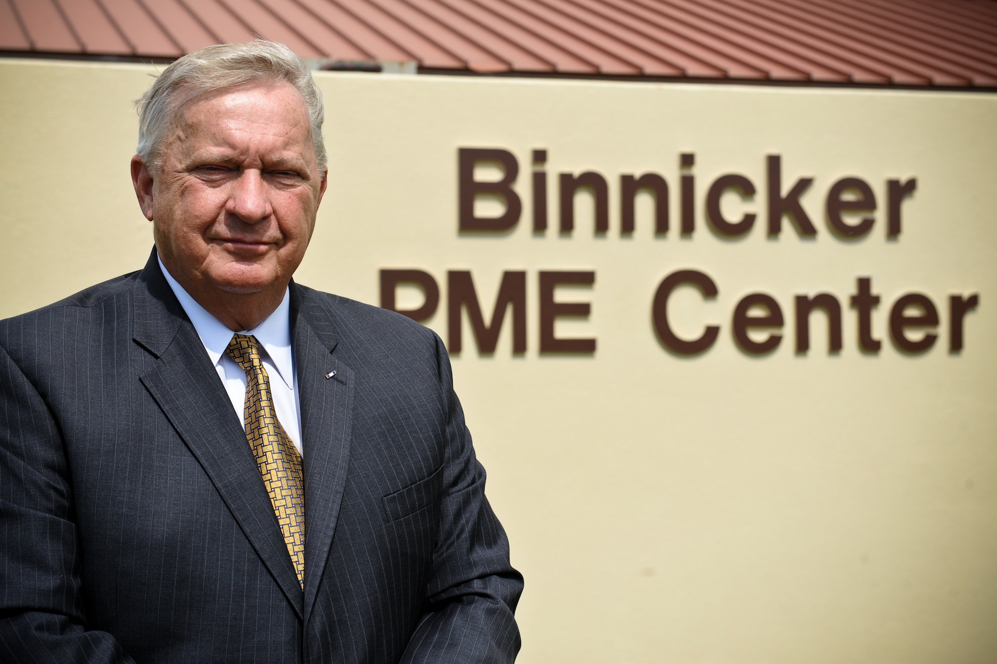 9th Chief Master Sgt. of the Air Force James Binnicker stands outside of the newly renamed Binnicker Professional Military Education Center at Joint Base Pearl Harbor-Hickam, Hawaii Feb. 15. Binnicker served a total of 17 assignments during his enlisted career, including a one-year assignment to the Republic of Vietnam. (U.S. Air Force photo/Staff Sgt. Mike Meares)