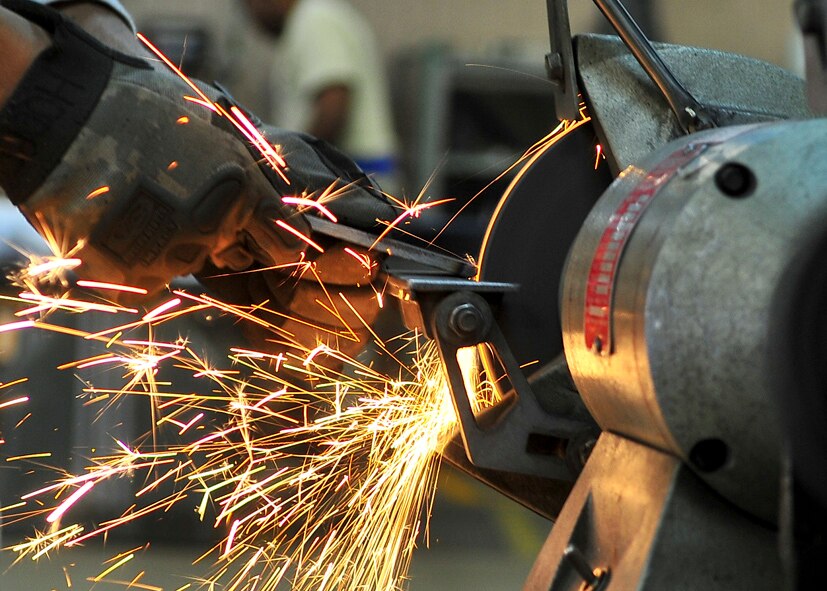 Sparks fly as Senior Airman James Turner, 51st Maintenance Group aircraft metal technology journeyman, uses a grinder Feb. 12, 2012. The grinder is used to remove poisonous or corrosive deposits located on the metal. (U.S. Air Force photo/Senior Airman Adam Grant) 