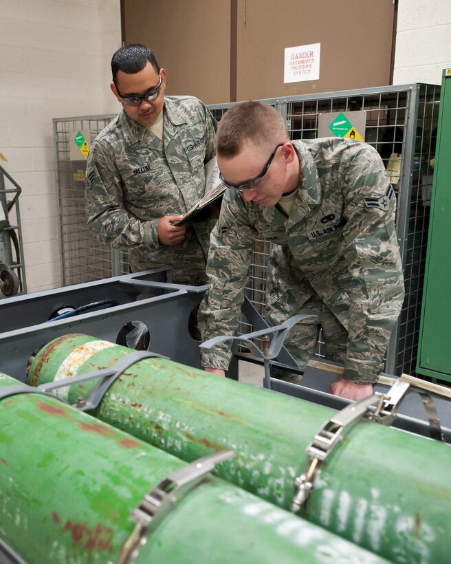 (From left) Senior Airman Anthony Yallum, and Airman 1st Class Bryan Dock, both 28th Maintenance Squadron electro-environmental systems technicians, replace bolts on a gaseous oxygen cart during routine maintenance at Ellsworth Air Force Base, S.D., Feb. 9, 2012. The oxygen tanks provide emergency back-up oxygen for pilots on the B-1B. (U.S. Air Force photo by Airman Alystria Maurer/Released)