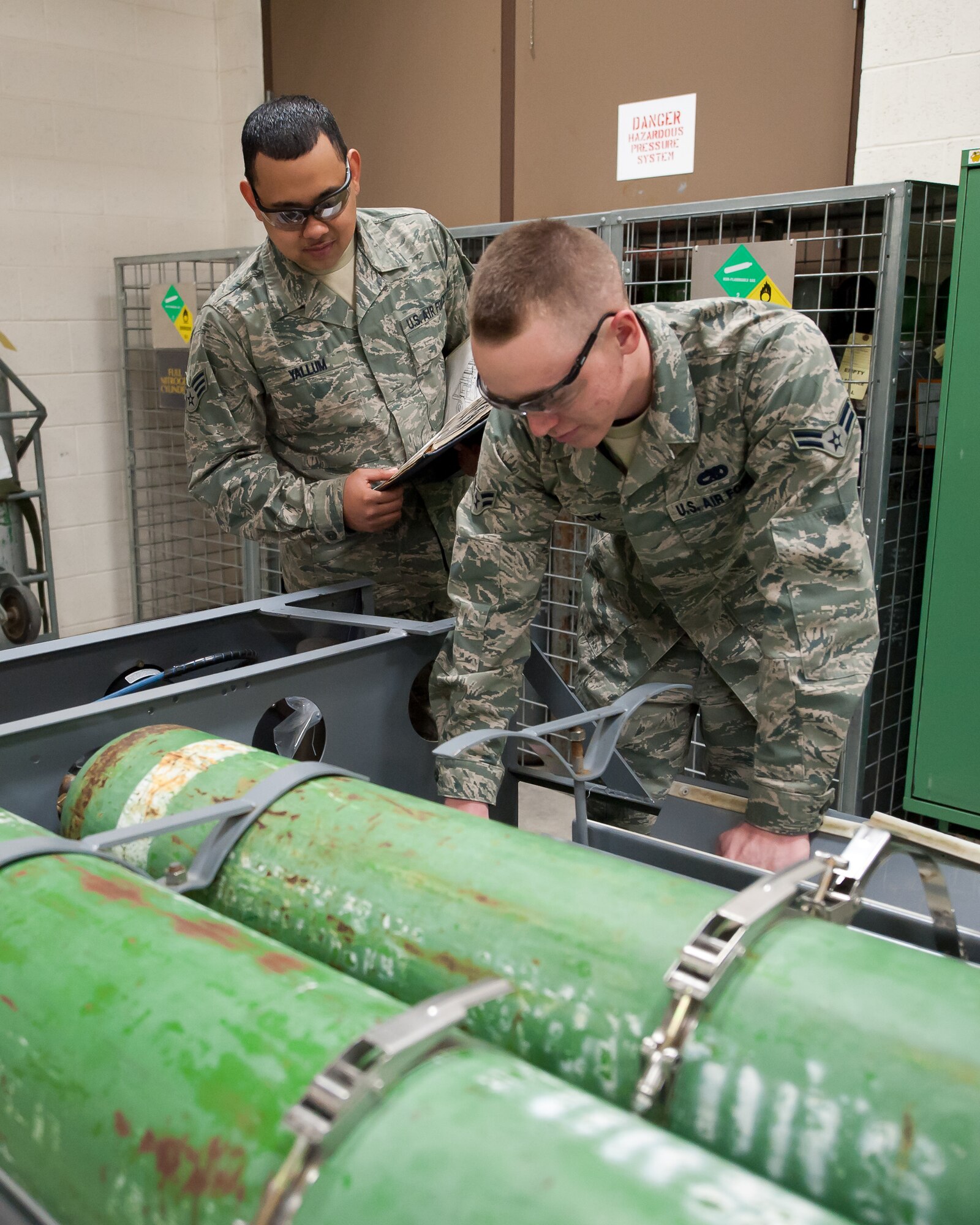 (From left) Senior Airman Anthony Yallum, and Airman 1st Class Bryan Dock, both 28th Maintenance Squadron electro-environmental systems technicians, replace bolts on a gaseous oxygen cart during routine maintenance at Ellsworth Air Force Base, S.D., Feb. 9, 2012. The oxygen tanks provide emergency back-up oxygen for pilots on the B-1B. (U.S. Air Force photo by Airman Alystria Maurer/Released)