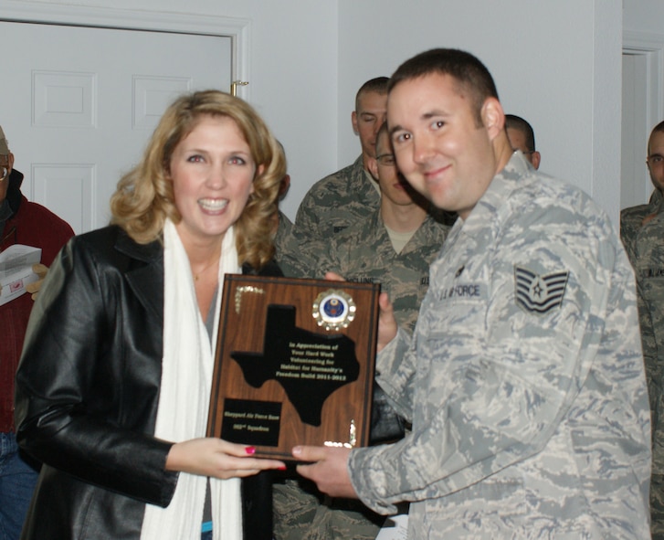 Tech. Sgt. Michael Corbitt from the 362nd Training Squadron receives a plaque from Habitat for Humanity executives during a home dedication ceremony Feb. 12, 2012 in Wichita Falls, Texas.  Members of the 362nd Training Squadron from Sheppard AFB, Texas recently completed the first-ever home build by an all-military manned volunteer crew for the Wichita Falls, Texas, Habitat for Humanity.  (U.S. Air Force photo/Dan Hawkins)