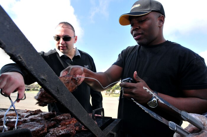 Tech Sgt. James Aguilar and Staff Sgt. Durell Lawton prepare steaks for the Valentine's Day 'Hearty Meal' luncheon on Feb 14, 2012 at Beale Air Force Base, Calif. Aguilar and Lawton are volunteers from the Rising 6 Organization to help boost morale by cooking a delicious meal. (U.S. Air Force photo by Airman 1st Class Rachael Kane/Released)

