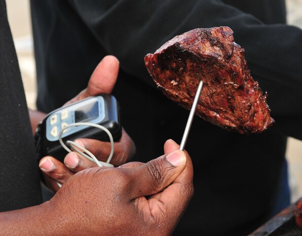 Staff Sgt. Durell Lawton, a member of Team Beale, tests a steak's temperature for the Valentine's Day 'Hearty Meal' luncheon on Feb 14, 2012 at Beale Air Force Base, Calif. The temperature of each steak has to be between 157 to 164 degrees in order to sell to patrons to meet health standards. (U.S. Air Force Photo by Airman 1st Class Rachael Kane/Released)