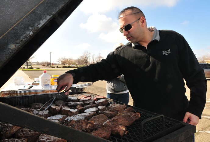 Tech. Sgt. James Aguilar a Team Beale member, flips thick steaks for the Valentine's Day 'Hearty Meal' drive event on Feb 14, 2012 at Beale Air Force Base, Calif. James volunteered with other members of Team Beale to help improve base morale by providing a delicious meal. (U.S Air Force Photo by Airman 1st Class Rachael Kane/Released)