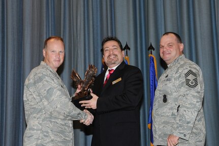 The annual Joint Base San Antonio-Randolph award winners were recognized during an awards ceremony at the base theater Feb. 14. Col. Scott Peel, 902nd Mission Support Group commander, left, and Chief Master Sgt. James Erwin, 902nd MSG superintendent, right, present the Supervisor Civilian Category II of the Year Award to Anthony Delgado from Air Force Personnel Operations Agency. (U.S. Air Force photo/Rich McFadden) (released)