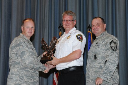 The annual Joint Base San Antonio-Randolph award winners were recognized during an awards ceremony at the base theater Feb. 14. Col. Scott Peel, 902nd Mission Support Group commander, left, and Chief Master Sgt. James Erwin, 902nd MSG superintendent, right, present the Supervisor Civilian Category I of the Year Award to Scott Ridenour from the 902nd MSG. (U.S. Air Force photo/Rich McFadden) (released)