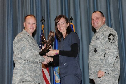 The annual Joint Base San Antonio-Randolph award winners were recognized during an awards ceremony at the base theater Feb. 14. Col. Scott Peel, 902nd Mission Support Group commander, left, and Chief Master Sgt. James Erwin, 902nd MSG superintendent, right, present the Non-Supervisor Civilian Category II of the Year Award to Brenda Wallsmith from the 359th Medical Group. (U.S. Air Force photo/Rich McFadden) (released)