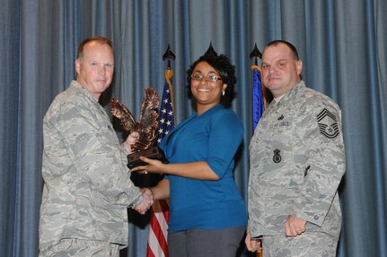 The annual Joint Base San Antonio-Randolph award winners were recognized during an awards ceremony at the base theater Feb. 14. Col. Scott Peel, 902nd Mission Support Group commander, left, and Chief Master Sgt. James Erwin, 902nd MSG superintendent, right, present the Non-Supervisor Civilian Category I of the Year Award to Antoinette Davis from Air Education and Training Command. (U.S. Air Force photo/Rich McFadden) (released)