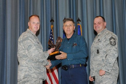 The annual Joint Base San Antonio-Randolph award winners were recognized during an awards ceremony at the base theater Feb. 14. Col. Scott Peel, 902nd Mission Support Group commander, left, and Chief Master Sgt. James Erwin, 902nd MSG superintendent, right, present the Wage Civilian Grade of the Year Award to Jerry Wilson from the 902nd MSG. (U.S. Air Force photo/Rich McFadden) (released)