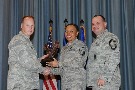 The annual Joint Base San Antonio-Randolph award winners were recognized during an awards ceremony at the base theater Feb. 14. Col. Scott Peel, 902nd Mission Support Group commander, left, and Chief Master Sgt. James Erwin, 902nd MSG superintendent, right, present the First Sergeant of the Year Award to Master Sgt. Yolanda Cole from the 12th Flying Training Wing. (U.S. Air Force photo/Rich McFadden) (released)