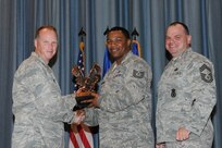 The annual Joint Base San Antonio-Randolph award winners were recognized during an awards ceremony at the base theater Feb. 14. Col. Scott Peel, 902nd Mission Support Group commander, left, and Chief Master Sgt. James Erwin, 902nd MSG superintendent, right, present the NCO of the Year to Tech. Sgt. Bruce Harrison from the 902nd MSG. (U.S. Air Force photo/Rich McFadden) (released)