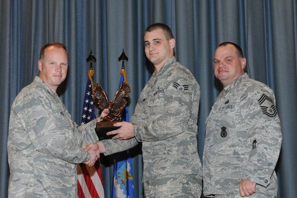The annual Joint Base San Antonio-Randolph award winners were recognized during an awards ceremony at the base theater Feb. 14. Col. Scott Peel, 902nd Mission Support Group commander, left, and Chief Master Sgt. James Erwin, 902nd MSG superintendent, right, present the Junior Enlisted Airman of the Year Award to Senior Airman Jared Vanwey from the 902nd MSG. (U.S. Air Force photo/Rich McFadden) (released)