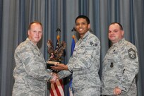 The annual Joint Base San Antonio-Randolph award winners were recognized during an awards ceremony at the base theater Feb. 14.  Col. Scott Peel, 902nd Mission Support Group commander, left, and Chief Master Sgt. James Erwin, 902nd MSG superintendent, right, present the Honor Guard Airman of the Year Award to Senior Airman Marcos Davis from the 359th Medical Group. (U.S. Air Force photo/Rich McFadden) (released)