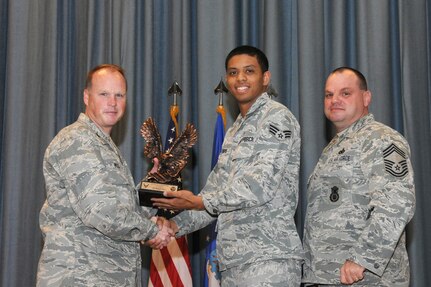 The annual Joint Base San Antonio-Randolph award winners were recognized during an awards ceremony at the base theater Feb. 14.  Col. Scott Peel, 902nd Mission Support Group commander, left, and Chief Master Sgt. James Erwin, 902nd MSG superintendent, right, present the Honor Guard Airman of the Year Award to Senior Airman Marcos Davis from the 359th Medical Group. (U.S. Air Force photo/Rich McFadden) (released)