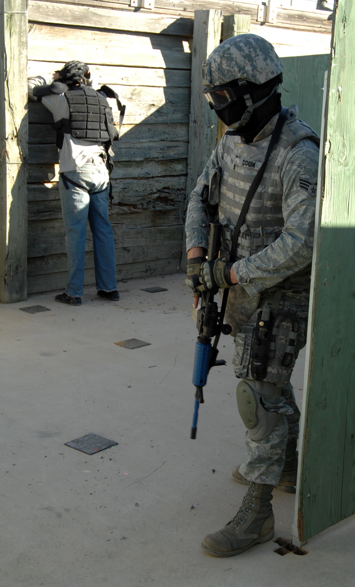 An Airman from the 355th Security Forces Squadron protects an innocent bystander and watches the backs of his teammates during the active shooter training exercise in Tucson, Ariz., Feb. 9. This scenario consisted of security forces entering a multi-room building, and clearing and securing the rooms one by one. (U.S. Air Force photo by Airman 1st Class Michael Washburn/Released)