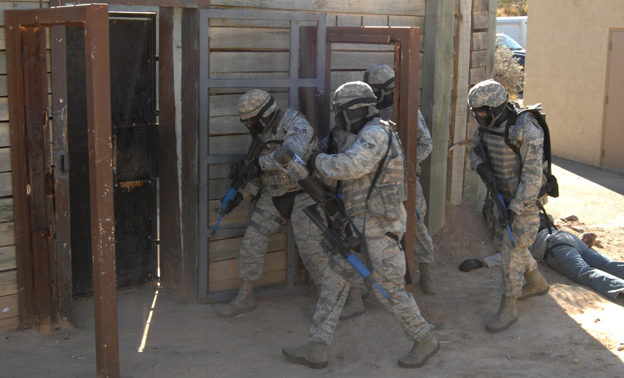 Airmen from the 355th Security Forces Squadron prepare to breach the door of a multi-room building during an active shooter training exercise in Tucson, Ariz., Feb. 9. After trying to enter the building and finding the door locked, security forces must breach it using a battering ram. (U.S. Air Force photo by Airman 1st Class Michael Washburn/Released)