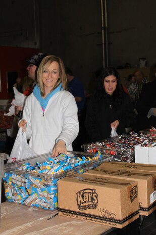 2nd Lt. Jessica Looft and 2nd Lt. Daneen Holmes, clinical nurses, 99thInpatient Operations Squadron, stand in line to assemble backpacks for kids with non-perishable food items Jan. 17th, 2012 inside the Three Square food bank's south campus warehouse. The Company Grade Officer's Counsel express giving back to the community by being involved in opportunities such as Three-Square and Habitat for Humanity. (U.S. Air Force photo by Capt. Leticia Venegas)
