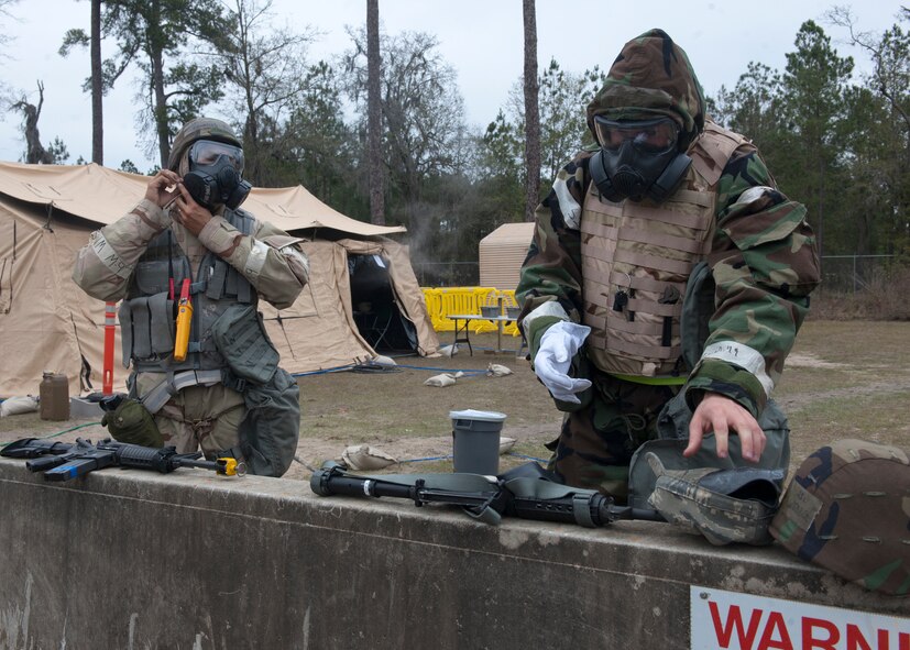 U.S. Air Force Staff Sgt. Emanuel Flores and Airman 1st Class Michael Webber, both from the 23d Civil Engineer Squadron, don chemical protective gear during a phase II operational readiness exercise at the field training exercise site Feb. 15, 2012, at Moody Air Force Base, Ga. If a chemical attack were to occur down range, it is critically important to put PPE on as quickly as possible to avoid exposure.. (U.S. Air Force photo by Senior Airman Eileen Meier/Released)