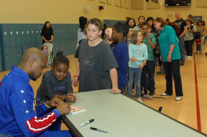 Harlem Globetrotter Shane "Scooter" Christensen, signs autographs for members of the Nellis community after demonstrating basketball tricks and speaking with fans Feb. 10th, 2012 at the Youth Center, Nellis Air Force Base, Nev. The Las Vegas native is in his seventh season with the Globetrotters and has played basketball in more than 50 countries during his time on the team. (U.S. Air Force photo by Staff Sgt. Taylor Worley)
