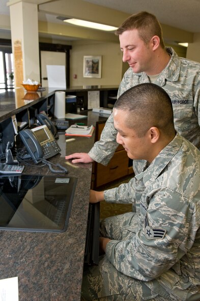 Staff Sgt. Billy Janca, 28th Force Support Squadron guest services manager, trains Senior Airman Roldan Corcuera, 28th Force Support Squadron guest support representative, on reserving rooms and check-in procedures at the Pine Tree Inn on Ellsworth Air Force Base, S.D., Feb. 8, 2012.  The Pine Tree Inn, with 32 visiting quarters and 8 business suites, is available to active duty, retirees, dependents and visitors assigned to Ellsworth.  (U.S. Air Force photo by Airman 1st Class Anania Tekurio/Released)