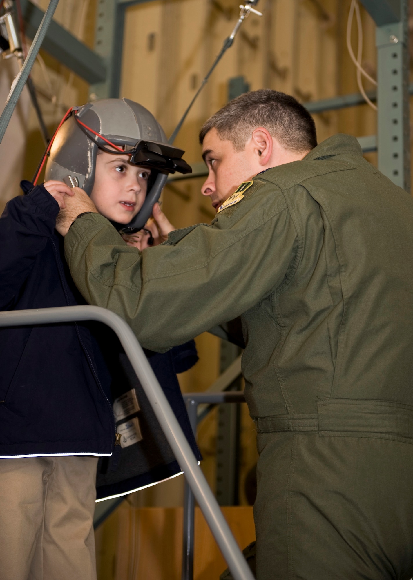 Capt. Kenneth Byrd, 2nd Operations Support Squadron, removes an aircrew helmet from a Providence Classical Academy student on Barksdale Air Force Base, La., Feb. 14. Children from PCA toured the base to gain a better perspective on the mission and duties of aircrew. (U.S. Air Force photo/Airman 1st Class Benjamin Gonsier)(RELEASED)