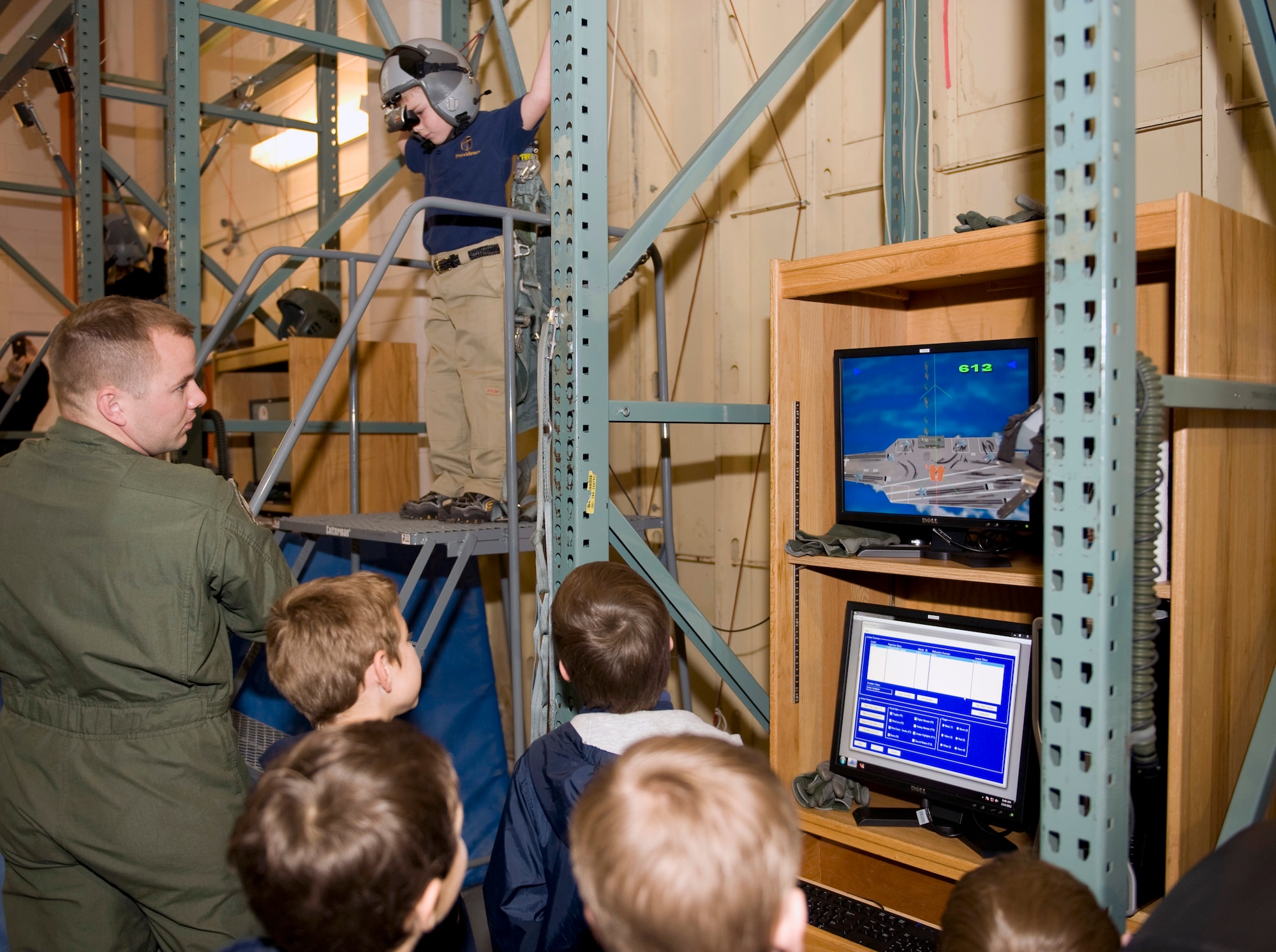 Tech. Sgt. Matthew Searby, 2nd Operations Support Squadron, and children from the Providence Classical Academy watch a parachute simulation on Barksdale Air Force Base, La., Feb. 14. Searby is a Survival, Evasion, Resistance and Escape specialists. The PCA students visited the base to get a glimpse of the type of training Air Force aircrew experience. (U.S. Air Force photo/Airman 1st Class Benjamin Gonsier)(RELEASED)