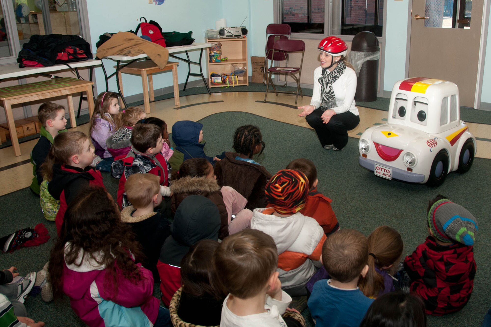Diana Imondi-Dias, along with Otto the Auto, talk about car safety with children at the Child Development Center Feb. 10. Besides car safety, Otto, a robot car, travels around and talks to kids about crossing the street and wearing helmets while on a bike. (U.S. Air Force photo by Linda LaBonte Britt)