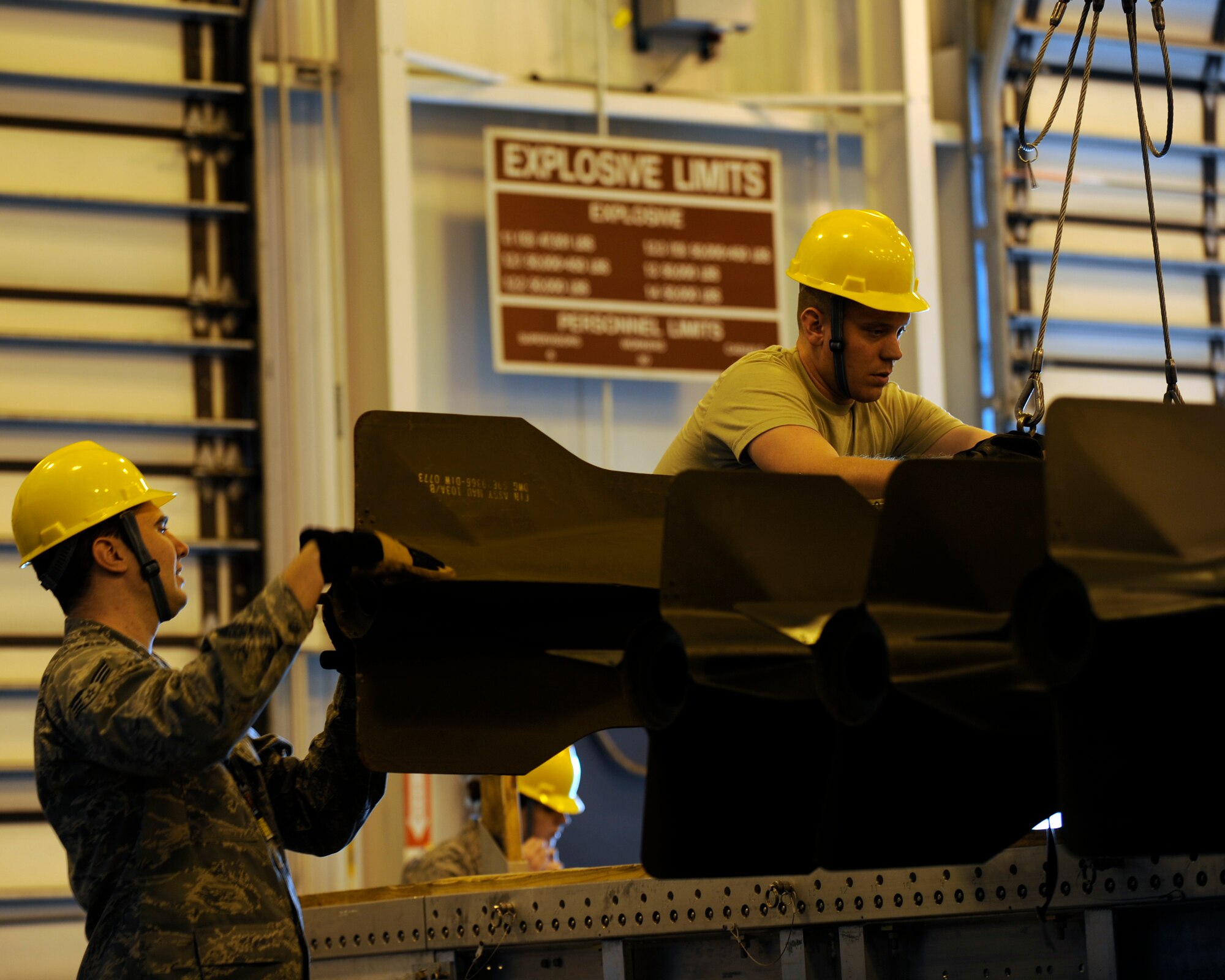 MINOT AIR FORCE BASE, N.D. -- Senior Airmen Kyle Gilbreaith and Ryan Heagy, 5th Munitions Squadron conventional maintenance crew members, load weapons systems onto a flatbed truck here Feb. 13. Constant situational awareness and teamwork is crucial in the safe and effective transport of weapons systems on the base. (U.S. Air Force photo/Airman 1st Class Stephanie Ashley)