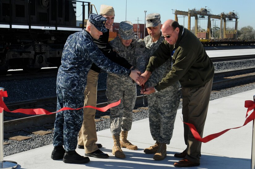 (Left to right) Lt. Cmdr. Stephen Fichter, Navy Capt. Ralph Ward, Army Maj. Gen. Kevin Leonard, Army Lt. Col. Robert Dawson and Terry Healey cut the ribbon during the 841st Transportation Battalion’s ribbon cutting and golden spike ceremony at Joint Base Charleston- Weapons Station Feb. 13.  The golden spike ceremony represents the completion of an eight-year, $9 million project that expanded the rail facility to eight lines. Fichter is the Naval Facilities Engineering Command resident officer in charge of construction, Ward is the JB Charleston deputy commander, Leonard is the Surface Deployment and Distribution Command commanding general, Dawson is the 841st Transportation Battalion commander and Healey is the Queen City Railroad Construction site safety health officer. (U.S. Navy photo/Petty Officer 2nd Class Brannon Deugan)