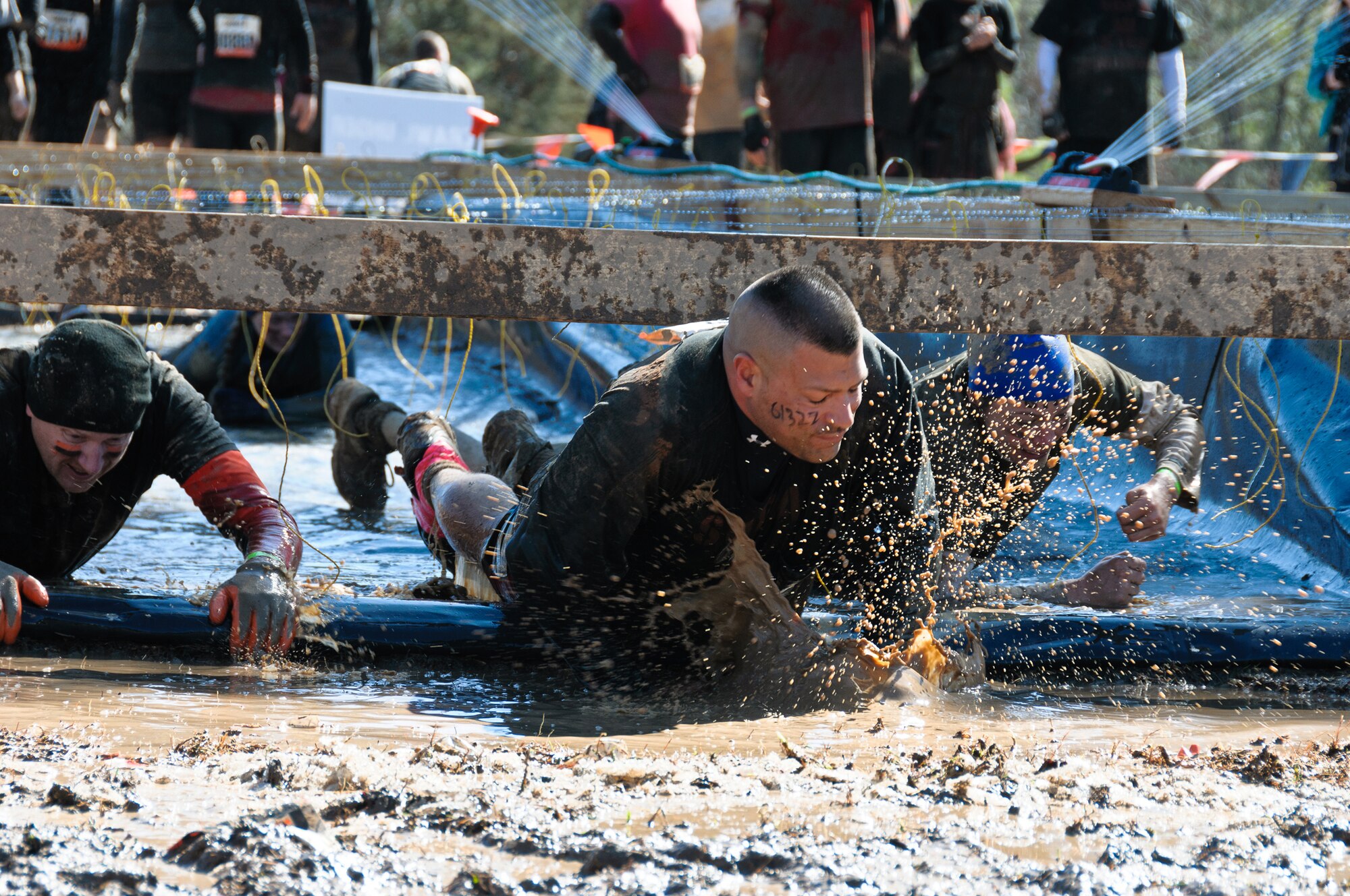 Maj. William Kerr (left) and Senior Master Sgt. Richard Roneree pull themselves through randomly electrified wires during the Tough Mudder event Feb. 12, 2012, in Washington, Ga.  Kerr is the chief of the Command, Control Intelligence Surveillance and Reconnaissance contracting branch, and Roneree is the Headquarters Air Force Reserve Command Recruiting Squadron officer accessions support; both are from Robins Air Force Base, Ga. (U.S. Air Force photo/Staff Sgt. Alexy Saltekoff)