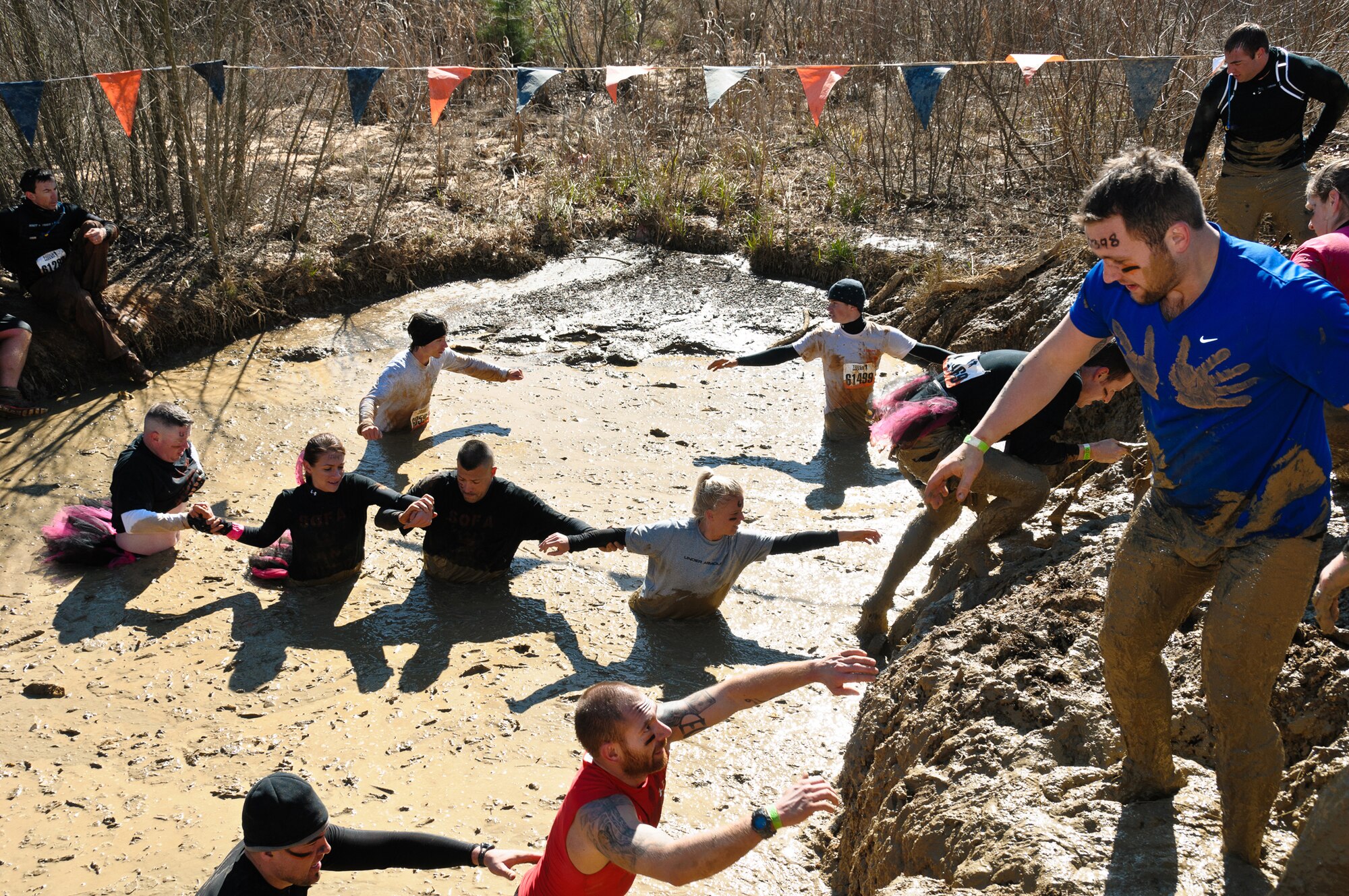 (Center from left) Staff Sgt. Jonathan Galvin, Staff Sgt. Crystal Traub, Senior Master Sgt. Richard Roneree and Capt. Kelli Rabideau form a line to help each other through the mud as 2nd Lt. Michael Bennett pulls himself up the bank during the Tough Mudder event Feb. 12, 2012, in Washington, Ga. Galvin, an Air Force Reserve Line Recruiter with the Headquarters Air Force Reserve Command Recruiting Squadron; Traub, a resource advisor for the HQ AFRC RS; Roneree, officer accessions support with the HQ AFRC RS; and Rabideau, the 951st RSPTS director of operations, are from Robins Air Force Base, Ga., and Bennett is from the 708th Test Squadron at Eglin Air Force Base, Fla. (U.S. Air Force photo/Staff Sgt. Alexy Saltekoff)